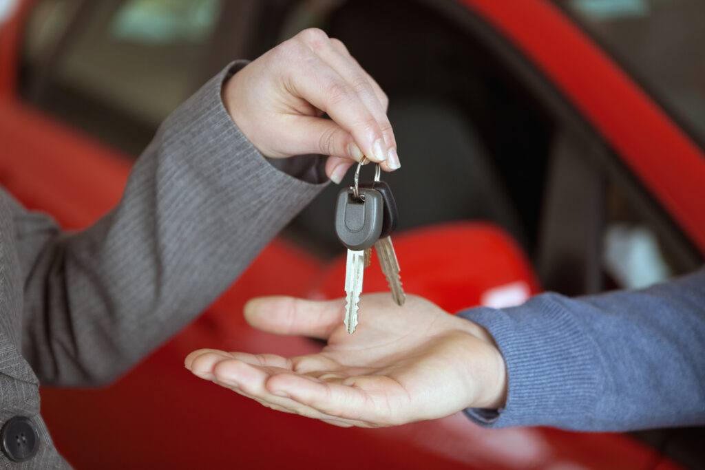 Person handing keys to someone else in a car shop